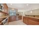 Open-concept kitchen featuring stainless steel appliances, wood cabinets, and a breakfast bar with backyard views at 3572 Ferndell, Sarasota, FL 34235