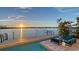 Waterfront pool area features a spacious deck, outdoor seating, and stunning water views at sunset at 360 N Washington Dr, Sarasota, FL 34236