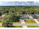 Beautiful aerial view of the property, showcasing the home, pool, and lush landscaping and surrounding wooded area at 4415 Sylvania Ave, North Port, FL 34286