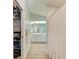 Hallway leading to a bathroom with shower, vanity, open closet and hardwood-style flooring at 4415 Sylvania Ave, North Port, FL 34286