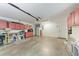 Spacious garage with red cabinets, utility sink, and concrete flooring, ideal for storage and projects at 4415 Sylvania Ave, North Port, FL 34286