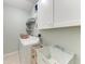 Functional laundry room featuring a washer, utility sink, storage cabinets, and practical shelving at 4415 Sylvania Ave, North Port, FL 34286