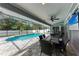 Covered pool patio includes a table setting with seating and a ceiling fan for comfortable outdoor living at 4415 Sylvania Ave, North Port, FL 34286