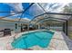 Backyard swimming pool enclosed by a screen, complemented by outdoor seating and BBQ grill at 4415 Sylvania Ave, North Port, FL 34286