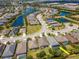 Aerial view of a community with lakes and many homes, highlighting a residence with a pool and screened enclosure at 4529 Golden Gate Cv, Bradenton, FL 34211