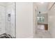 Modern bathroom featuring a tiled shower and a view to the bedroom with wood floors at 4529 Golden Gate Cv, Bradenton, FL 34211
