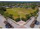 An aerial view of the park shows a large manicured field, walking paths, benches, and beautifully landscaped entrance at 4529 Golden Gate Cv, Bradenton, FL 34211