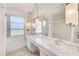 Bright bathroom featuring dual sinks, a large mirror with decorative lighting, and a shower-tub combination at 4908 Commonwealth Rd, Palmetto, FL 34221