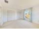 Bright bedroom featuring a ceiling fan, ample closet space, and a window providing natural light at 4908 Commonwealth Rd, Palmetto, FL 34221