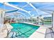 Enclosed pool area with clear blue water, surrounded by a screened enclosure and a waterfront view at 4908 Commonwealth Rd, Palmetto, FL 34221