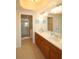 Bathroom with double sink vanity, large mirror, and a glass enclosed walk-in shower at 501 Haben Blvd # 704, Palmetto, FL 34221