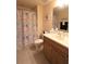 Well-lit bathroom features a shower with nautical-themed curtain and vanity with a wood cabinet at 501 Haben Blvd # 704, Palmetto, FL 34221