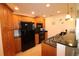 Contemporary kitchen featuring a bar, granite countertops, and black appliances at 501 Haben Blvd # 704, Palmetto, FL 34221