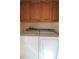 Laundry area featuring a washer and dryer under wood cabinets at 501 Haben Blvd # 704, Palmetto, FL 34221