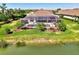 A stunning aerial perspective of a home with a screened-in pool overlooking a pond, nestled within a well-kept community at 5437 Manchini St, Sarasota, FL 34238