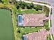 An aerial view of a beautiful home with a screened-in pool surrounded by lush landscaping and a serene lake at 5437 Manchini St, Sarasota, FL 34238