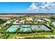 Aerial view of the tennis courts, clubhouse, pool, and surrounding homes in this vibrant community at 5437 Manchini St, Sarasota, FL 34238
