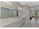 A spacious bathroom with a shower, dual sinks and a view of the bedroom at 5437 Manchini St, Sarasota, FL 34238