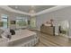 A stylish bedroom featuring a tray ceiling, lake view, and wood-look flooring at 5437 Manchini St, Sarasota, FL 34238