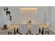A modern dining table, with chairs, and a silver light fixture at 5437 Manchini St, Sarasota, FL 34238