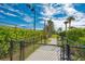 Fenced dog park with secure gated entry, a winding path, and tropical trees in a well-maintained green space at 5437 Manchini St, Sarasota, FL 34238