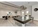 Spacious game room offering a ping pong table and comfortable lounge areas with elegant lighting fixtures and bright windows at 5437 Manchini St, Sarasota, FL 34238