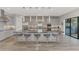 Spacious kitchen with gray cabinets, mosaic backsplash, and an oversized island with seating and views to the outdoor patio at 5437 Manchini St, Sarasota, FL 34238