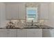 Kitchen counter area with gray cabinets and a decorative mosaic backsplash, overlooking the sink and window at 5437 Manchini St, Sarasota, FL 34238