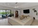 Modern living space with a large television and open access to an outside pool and patio at 5437 Manchini St, Sarasota, FL 34238