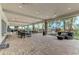 Spacious covered patio featuring comfortable seating, dining tables, and views of lush tropical landscaping and pool at 5437 Manchini St, Sarasota, FL 34238