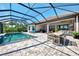Inviting screened-in pool with outdoor dining area and covered patio provides the perfect space to relax and entertain at 5437 Manchini St, Sarasota, FL 34238
