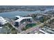 An aerial view shows the beautiful building, waterfront access, a pool, and a tennis court at 5855 Midnight Pass Rd # 512, Sarasota, FL 34242