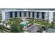 View of a large condo building with pool, parking, and a well-maintained green space at 5855 Midnight Pass Rd # 512, Sarasota, FL 34242
