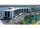 A waterfront condo building with a parking lot and beautifully landscaped pond with a fountain at 5855 Midnight Pass Rd # 512, Sarasota, FL 34242
