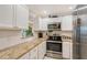 Modern kitchen featuring granite countertops, stainless steel appliances, and white cabinets at 5855 Midnight Pass Rd # 512, Sarasota, FL 34242
