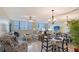 Bright living room featuring tile floors, plantation shutters, and dining area with mirrored wall at 5855 Midnight Pass Rd # 512, Sarasota, FL 34242