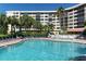 Resort style pool and lounge chairs with tropical landscaping and a nearby building at 5855 Midnight Pass Rd # 512, Sarasota, FL 34242