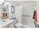 This bathroom features a white sink, vanity, toilet, shower, and shower curtain at 6047 Arlene Way, Bradenton, FL 34207
