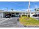 Street view of a single story home with a carport, well-kept lawn and driveway with parked cars at 6047 Arlene Way, Bradenton, FL 34207