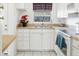 Well-maintained kitchen featuring tiled floor, white cabinets, and essential appliances at 6047 Arlene Way, Bradenton, FL 34207