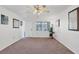 Bright living room with neutral carpet, white walls, a ceiling fan, and plenty of natural light at 6047 Arlene Way, Bradenton, FL 34207