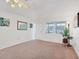 Bright living room with neutral carpet, white walls, a ceiling fan, and plenty of natural light at 6047 Arlene Way, Bradenton, FL 34207