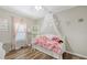 Cute bedroom with wood-look floors, canopy bed, and charming decor at 6365 Jim Davis Rd, Parrish, FL 34219