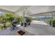 Spacious carport featuring a golf cart, grill, brick pavers, and lush landscaping, perfect for outdoor entertaining at 6365 Jim Davis Rd, Parrish, FL 34219