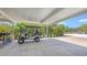 Carport featuring a golf cart and smooth concrete flooring, ideal for vehicle parking and storage at 6365 Jim Davis Rd, Parrish, FL 34219