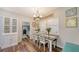Dining room with wood-look floors, a decorative chandelier, and plenty of natural light at 6365 Jim Davis Rd, Parrish, FL 34219