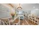 Bright dining area with hardwood floors, chandelier, and shuttered windows, connecting to the open-concept living space at 6365 Jim Davis Rd, Parrish, FL 34219