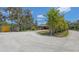 Property with mature trees and landscaping, featuring a long driveway and providing privacy and curb appeal at 6365 Jim Davis Rd, Parrish, FL 34219