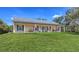 Inviting single-story home with a covered porch, manicured lawn, and cheerful blue front door at 6365 Jim Davis Rd, Parrish, FL 34219