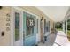 Charming front porch with a welcoming wreath, blue door, and outdoor seating at 6365 Jim Davis Rd, Parrish, FL 34219